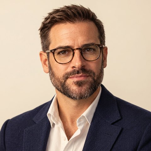 Illustrated portrait of Jeff Paroddy, glasses, navy jacket, on a cream background